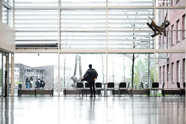 A student at the window in A Building. Photo.